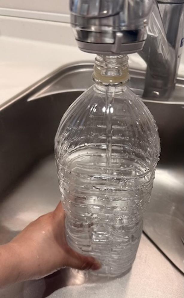 ペットボトルに水を入れる（▶次へ） 撮影／ゆき