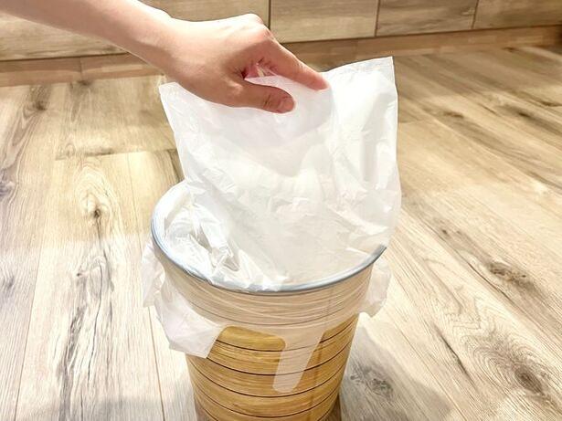 ゴミ袋をゆっくりとゴミ箱に押し込む（▶次へ） 撮影／りょう