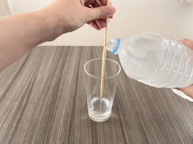 箸の上部を持って立て、ペットボトルの口を当てる（▶次へ） 撮影／なゆこ