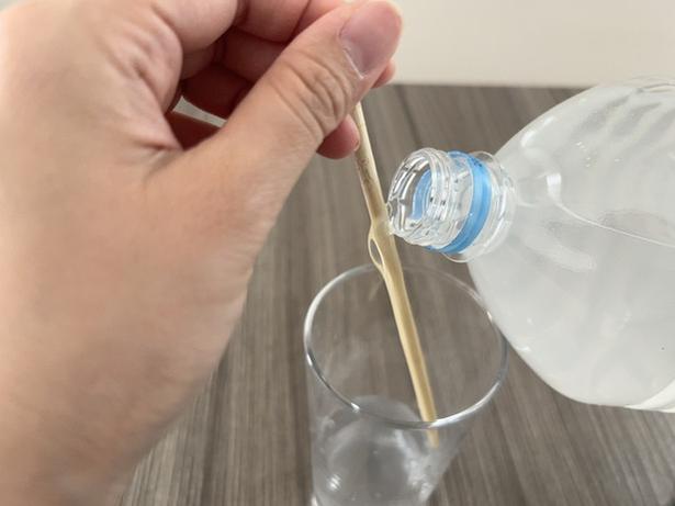 ペットボトルをゆっくり傾け、中身を箸に伝わせて注ぐ(▶結果へ) 撮影/なゆこ