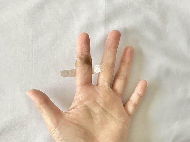 両端から切れ目を入れた粘着テープの上側2本を、関節の上部分でクロス！（▶次へ） 撮影／さわ子