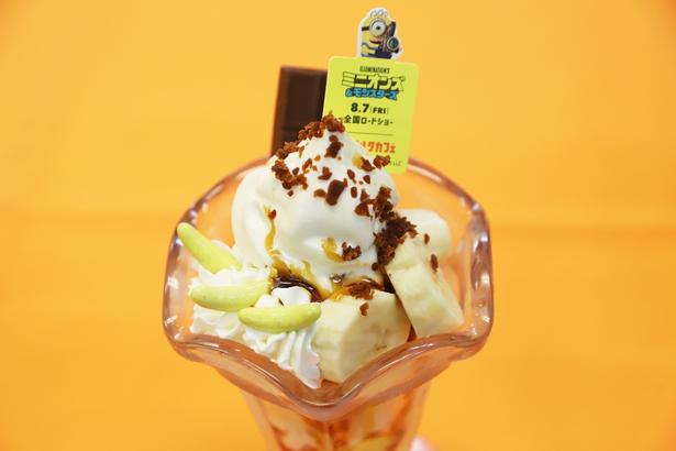 ミニオンズのオリジナルピックを添えて提供される「ミニオンズ チョコっとゆかいなバナナパフェ コラボチャーム付き」(1200円)。パリパリ食感のバナナ形チョコレートがアクセントをプラス！