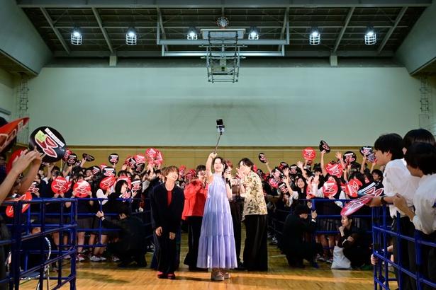 自撮り棒を使って生徒たちと360度記念撮影を行うMOMONA
