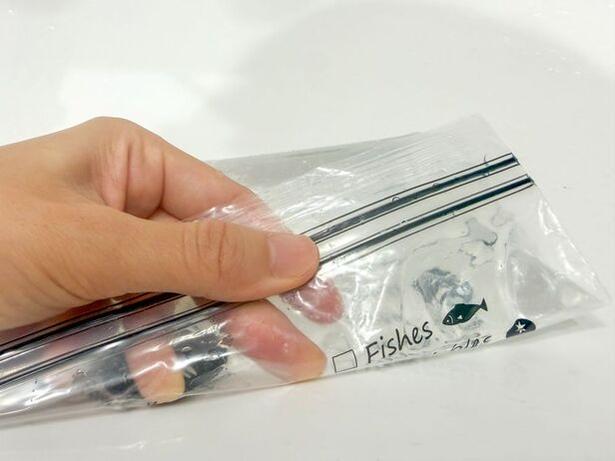 空気を抜きながらジップ付き保存袋の口を閉じる(▶次へ) 撮影/こぽり