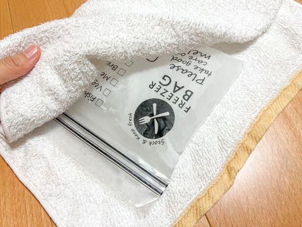 凍ったジップ付き保存袋をタオルで包む(▶次へ) 撮影/こぽり