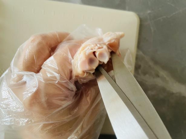 骨の周りの筋をキッチンバサミで断ち切る（▶次へ） 撮影／かに