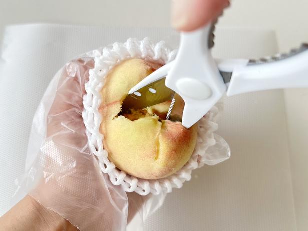 キッチンバサミを左右に揺らしながら、種と果肉を離します（▶次へ） 撮影／ひとか