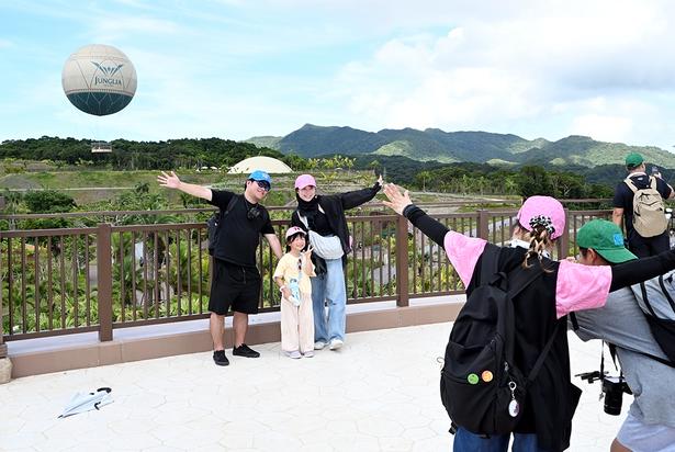 気球と大自然を背に記念撮影する来園者たち