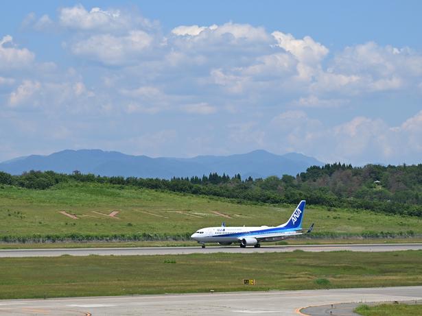 滑走路の向こうに見える「AKITA」のロゴ