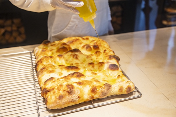 直焼きフォカッチャは、焼き上がりにオリーブオイルをたっぷりかけて仕上げられる