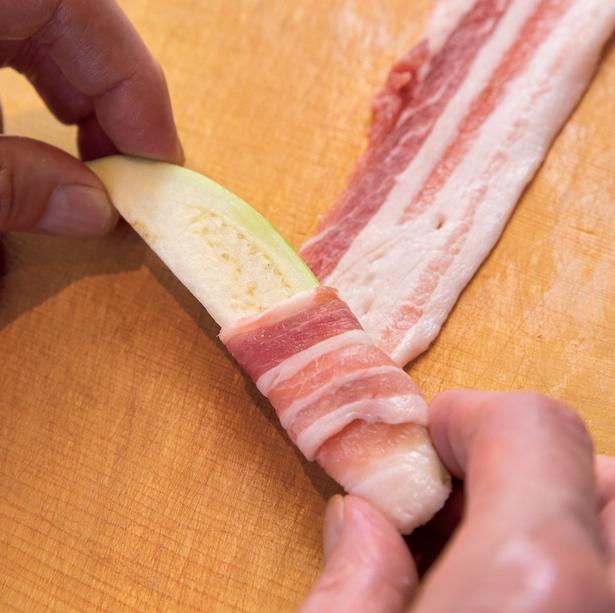 なすをやや斜めに置いて転がしながら、豚肉をくるくるとすき間なく巻きつけます レシピ考案／笠原将弘　撮影／広瀬貴子　