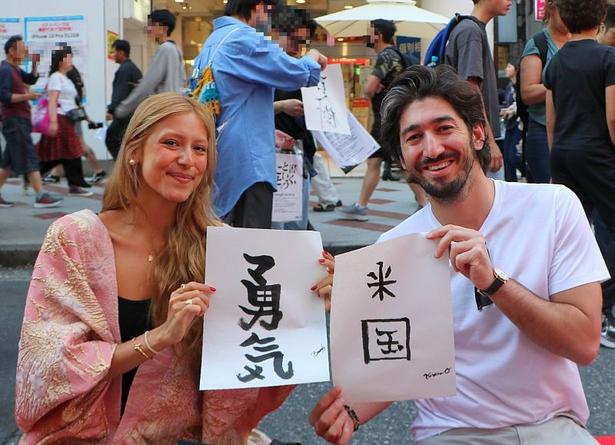 【写真】外国人観光客もレッドカーペットの上で“書道”にトライ!