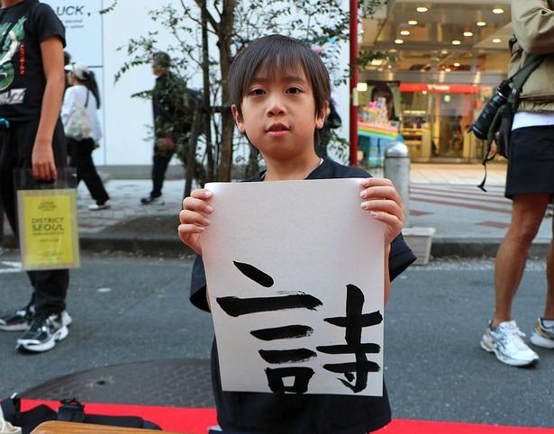 書道体験イベントには親子連れも参加していた。彼は、自身の名前の一部を選択。ママは「渋谷の路上で書道できるなんて貴重な機会ですね」と話していた