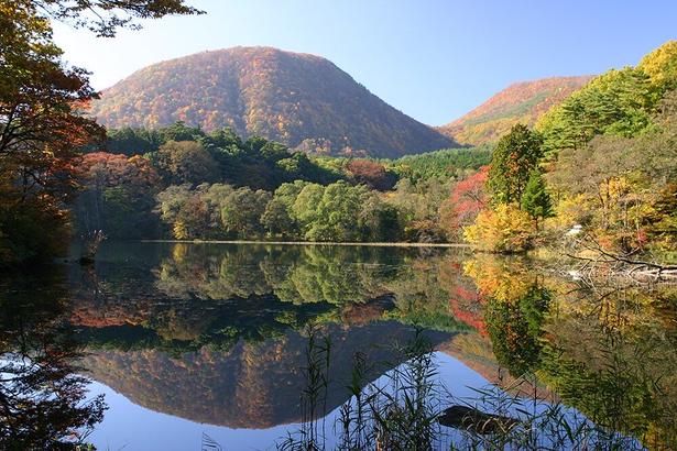 鏡のような水面には赤く染まった山々が映る/土湯温泉の紅葉 画像提供:土湯温泉観光協会
